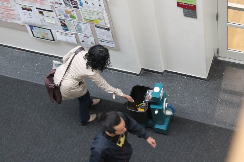 Participants crouching to help the robot pick up spilled M&Ms