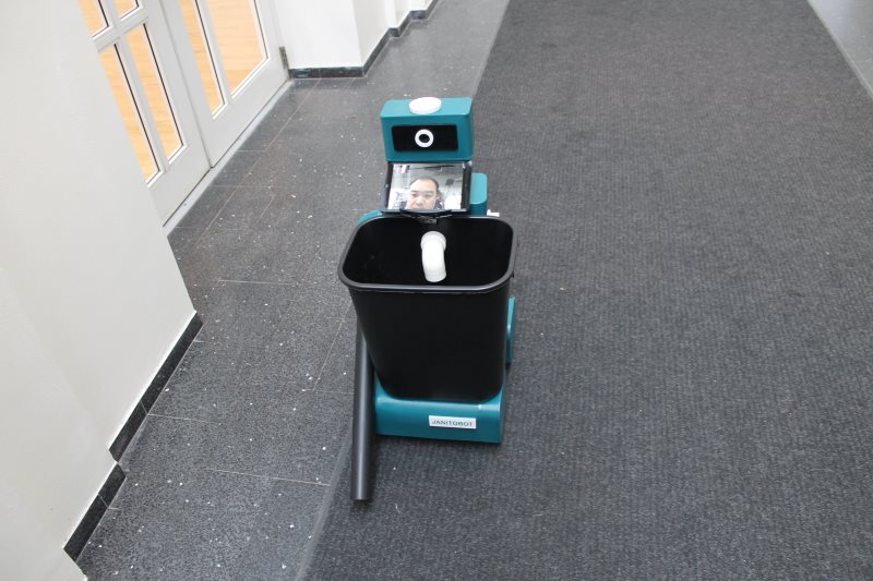 Final assembled Janitobot in hallway with iPad neck display showing operator