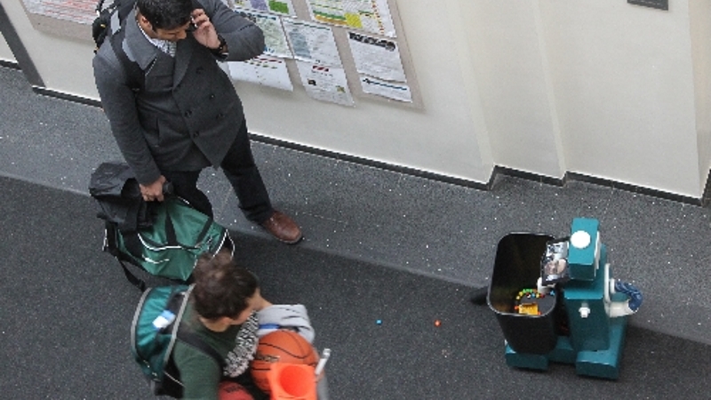 Janitobot fully assembled and operational in a CMU hallway, iPad mounted at neck