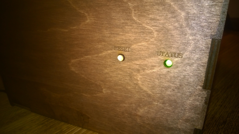 Side of box with wooden peg button and green LED installed