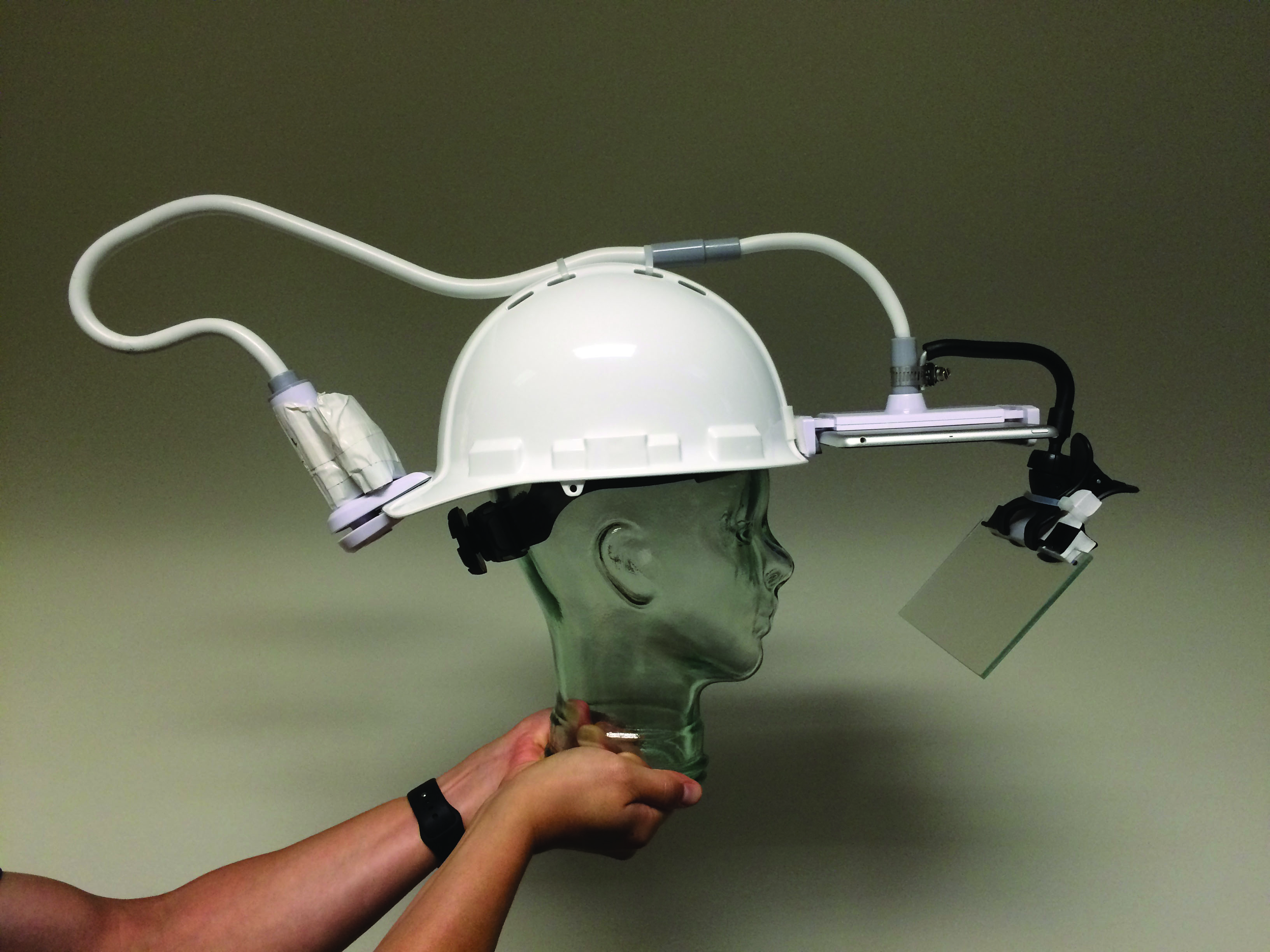 Team member wearing the completed Parallax AR helmet prototype, performing a procedure on the rodent habitat mockup