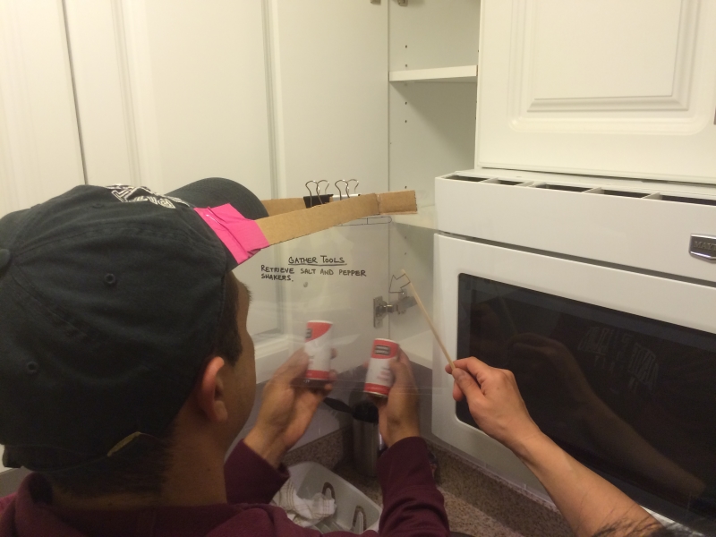 Low-fidelity prototype test: participant follows recipe instructions on a projected screen while an arrow points to ingredients