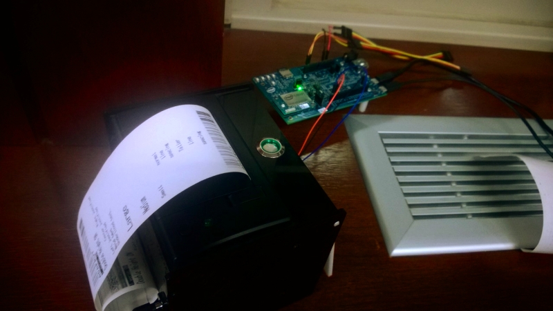 Team member testing thermal printer output — printed text on receipt paper