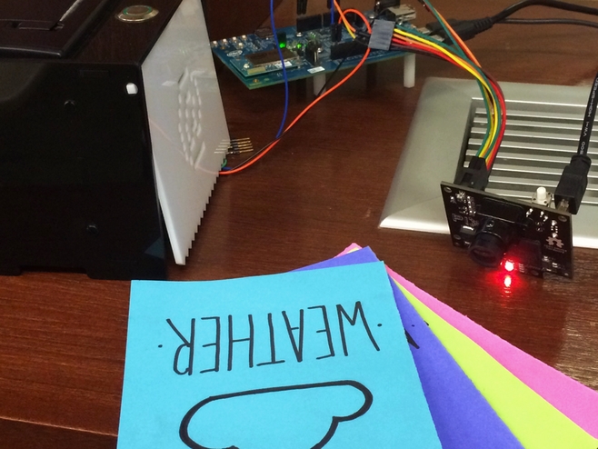 Mago system showing colored paper cards, PixyCam, and thermal printer on a table